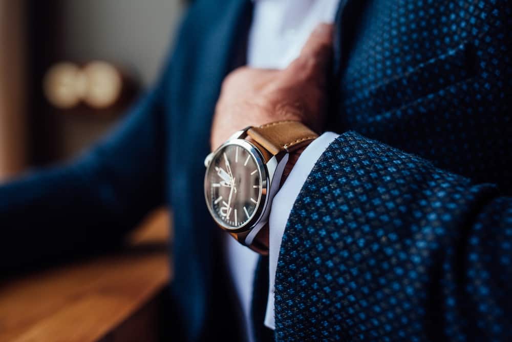 Man in a formal coat wearing watch.