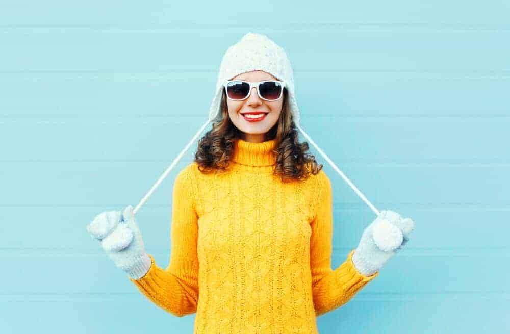 Une femme s'amuse avec son haut d'hiver jaune vif.