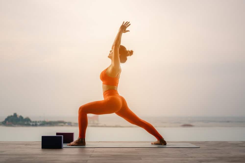 A woman wearing wide waist yoga pants at the pier.