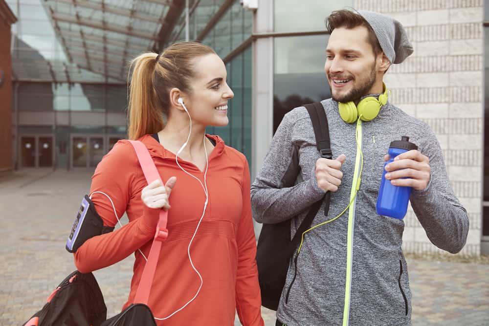 A couple wearing workout clothes on their way home from the gym.