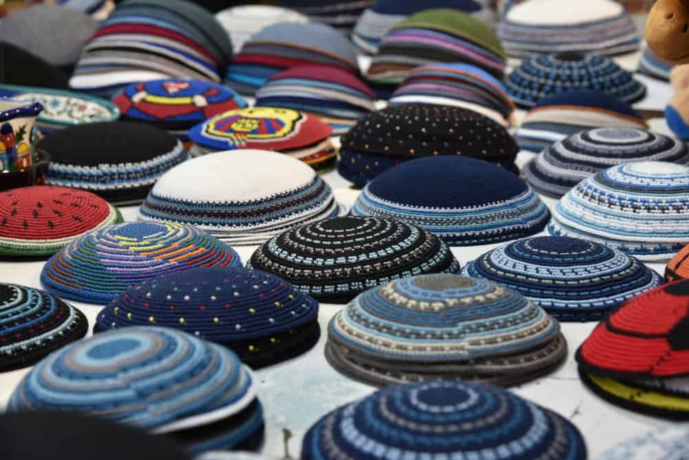 This is a close look at various colorful yarmulke hats on display.