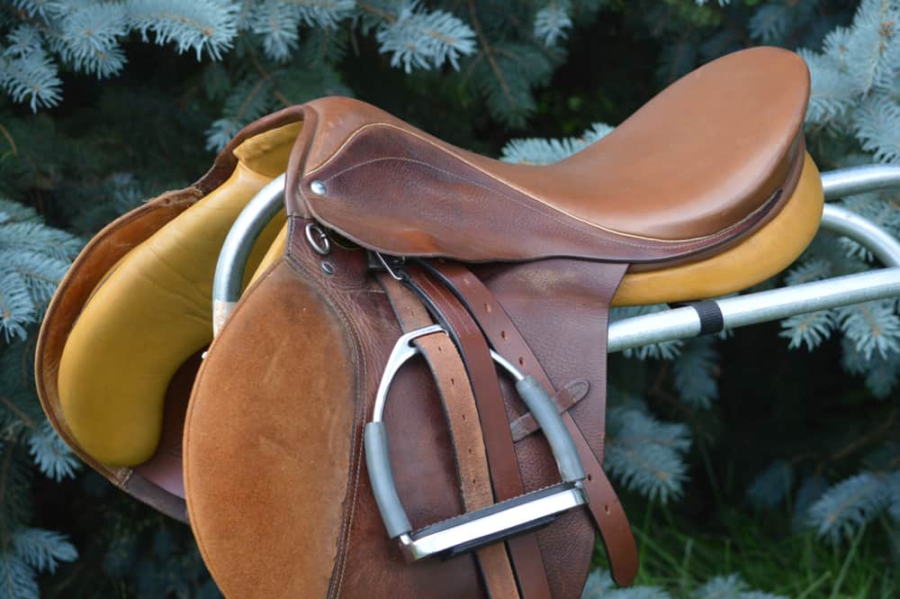 This is a brown leather suede riding saddle on display.