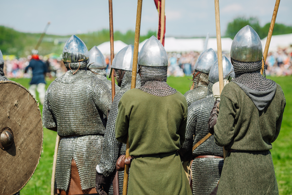 Back profile of knights wearing tin helmets.