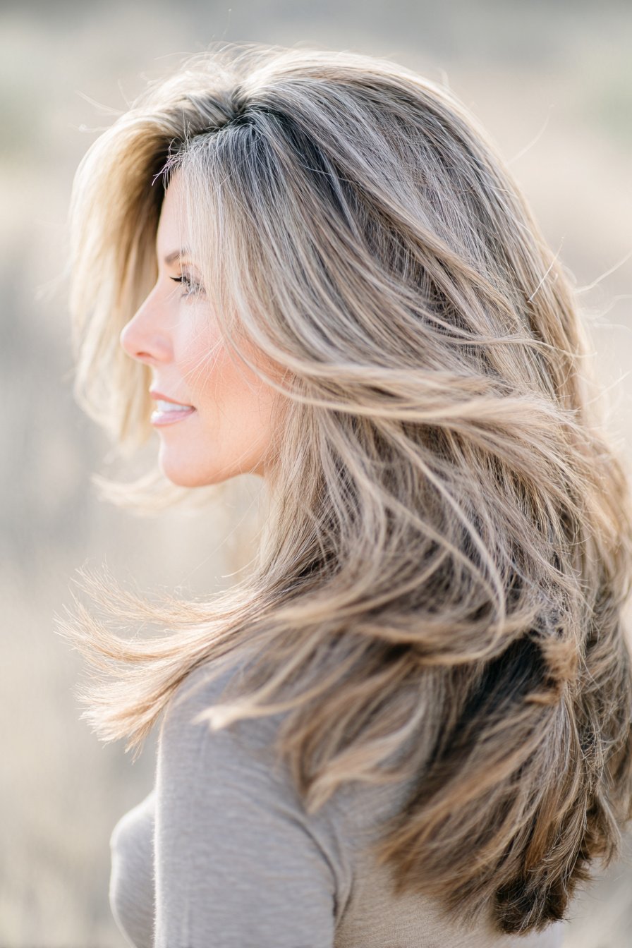 photorealistic image of long hair with airy layered movement, 40 year old woman, attractive but not model posing, natural effortless style