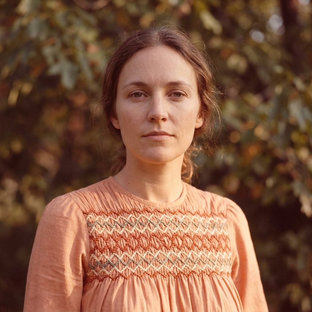 Peach prairie dress with decorative smocking across the bodice