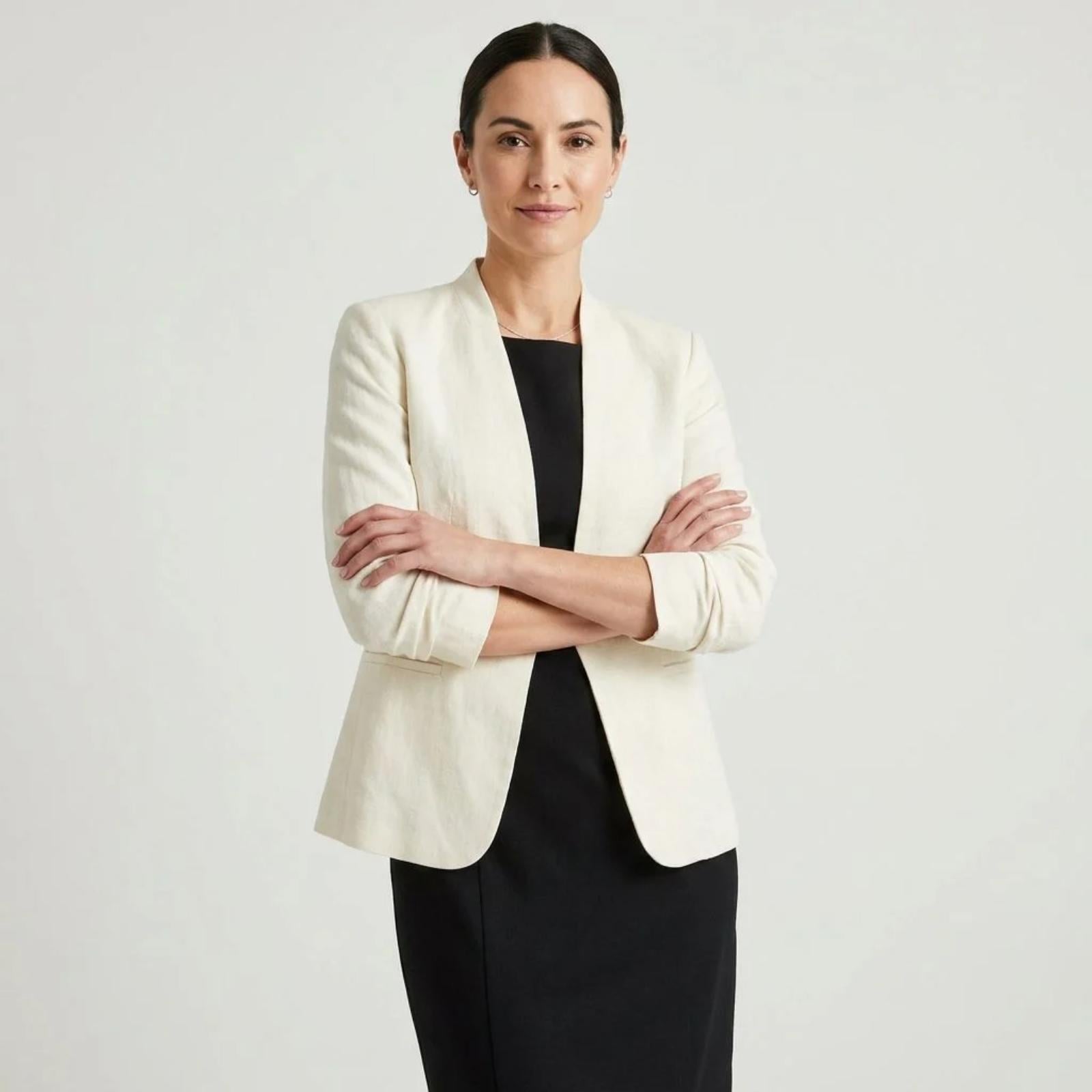 Cream collarless linen blazer layered over a black dress for a graphic black-and-white reset