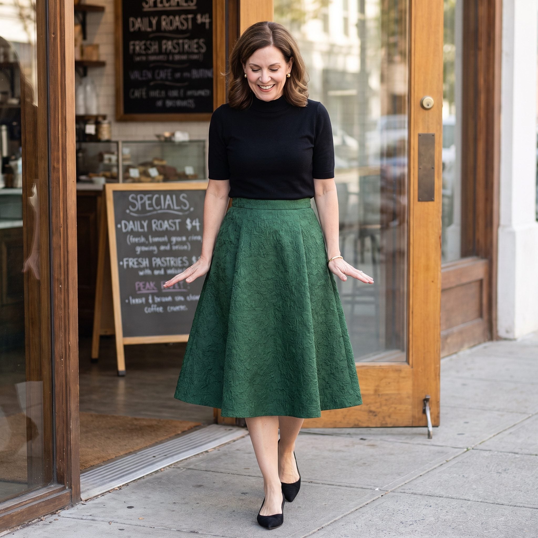 Forest-green jacquard A-line midi skirt paired with a black mock-neck top