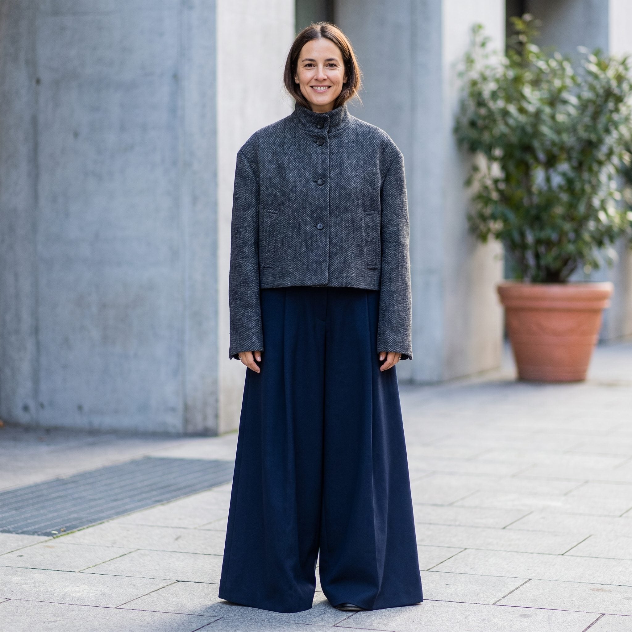 Woman in a boxy cream cropped jacket and full camel wide trousers, both pieces equally wide with no waist visible.