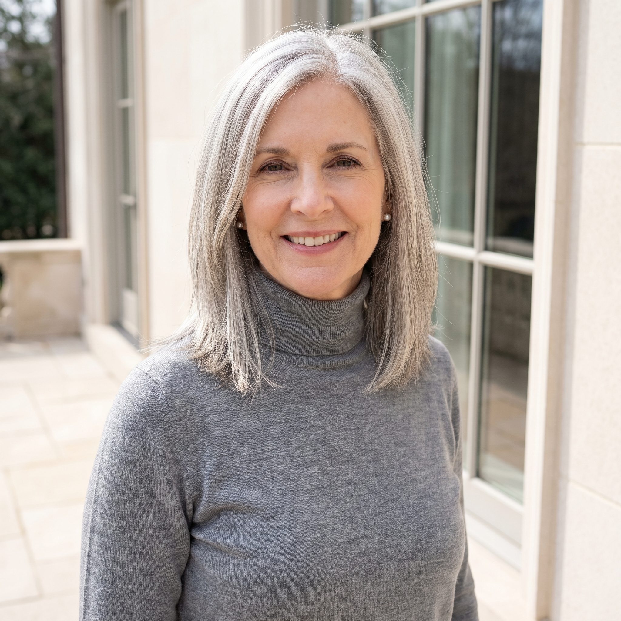 American woman with fine silky silver-gray hair whose choppy textured layers slide flat and fall into thin see-through