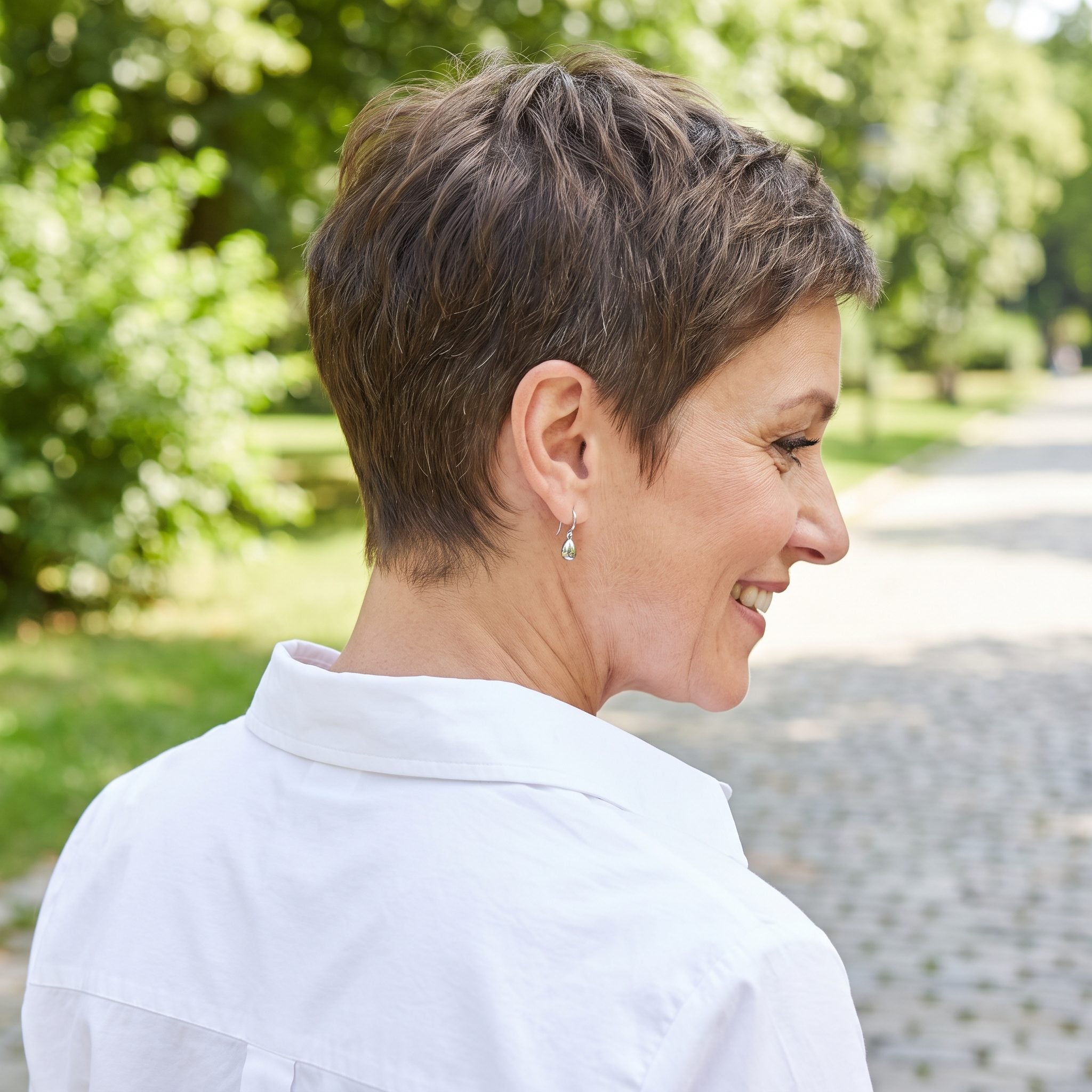 Woman with a short pixie and an undefined fuzzy nape at the neckline