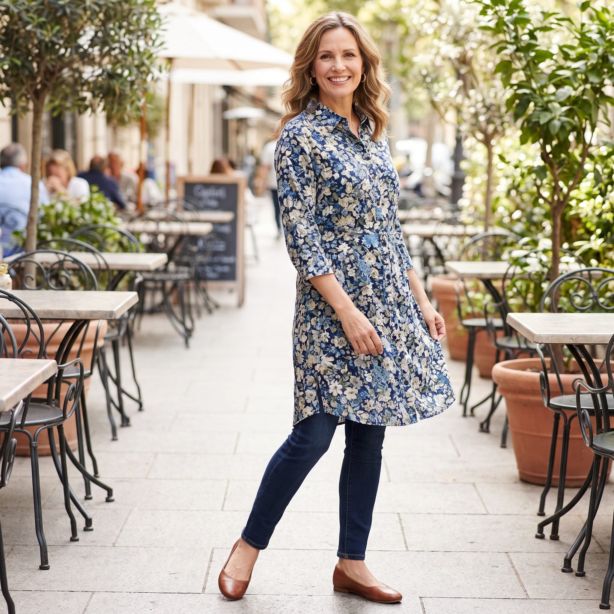 Woman in dark-wash skinny jeans under a knee-length floral shirt dress worn fully buttoned.