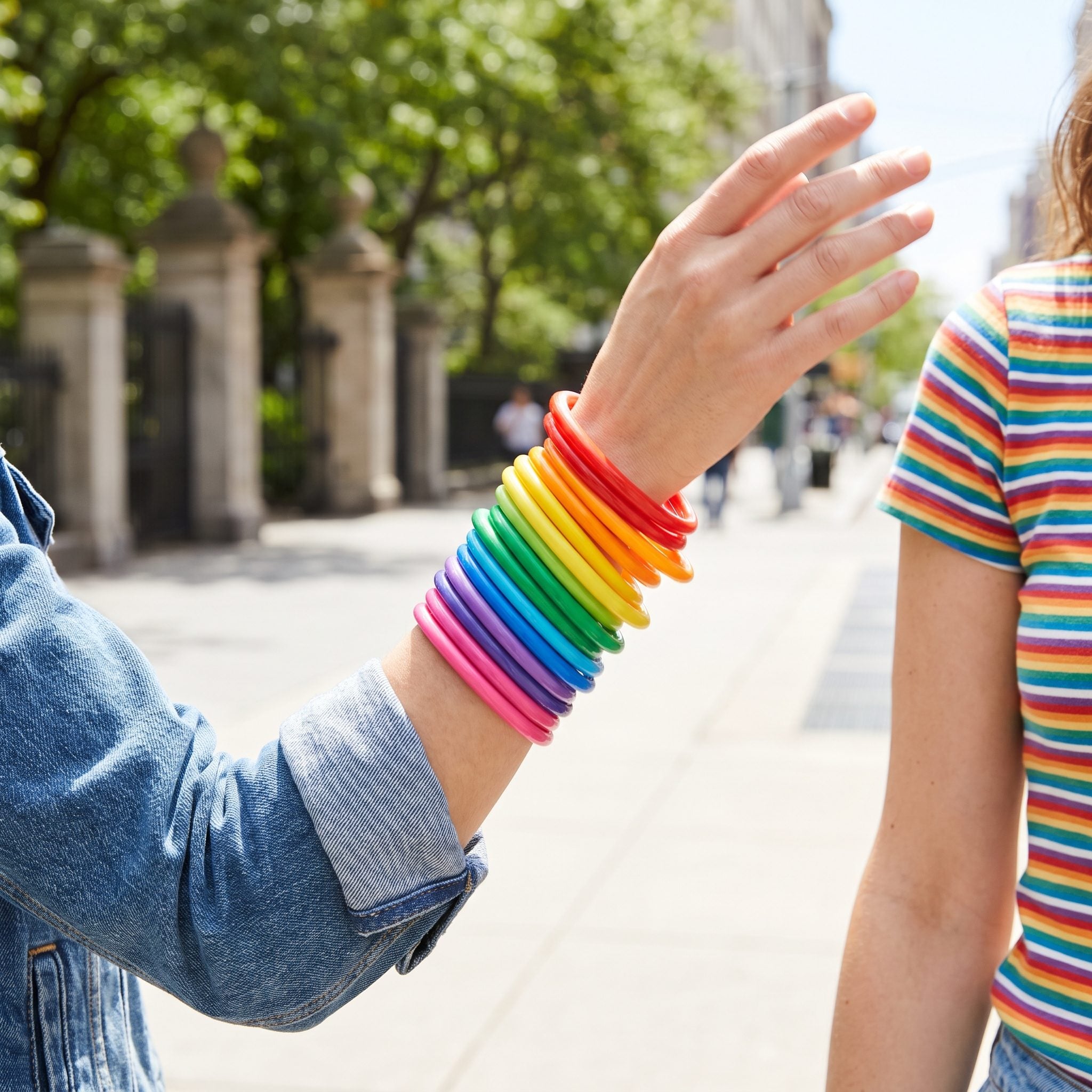 Stacked Bright Plastic Bangles Up the Forearm