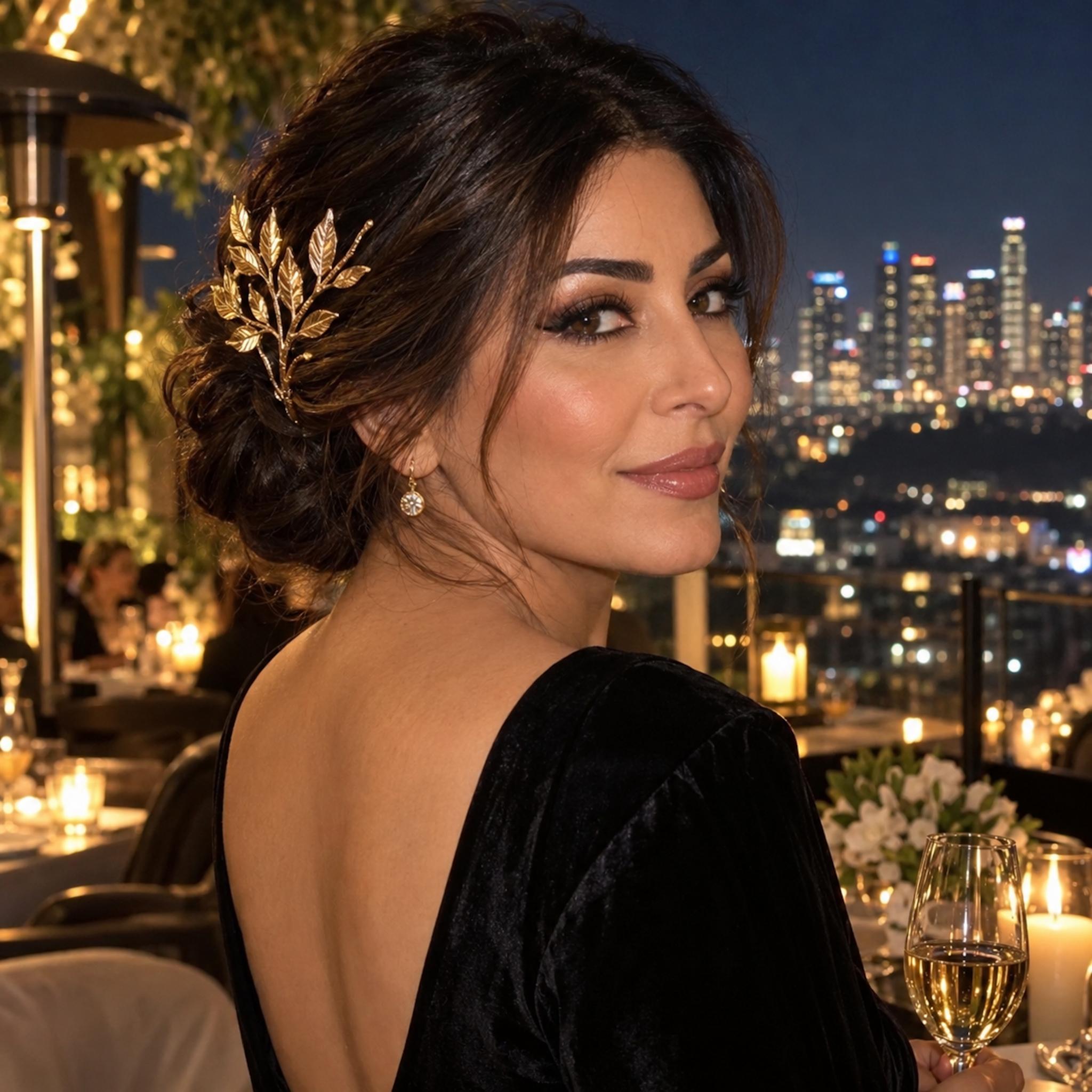 Low updo with a sculptural gold leaf comb on a nighttime city terrace