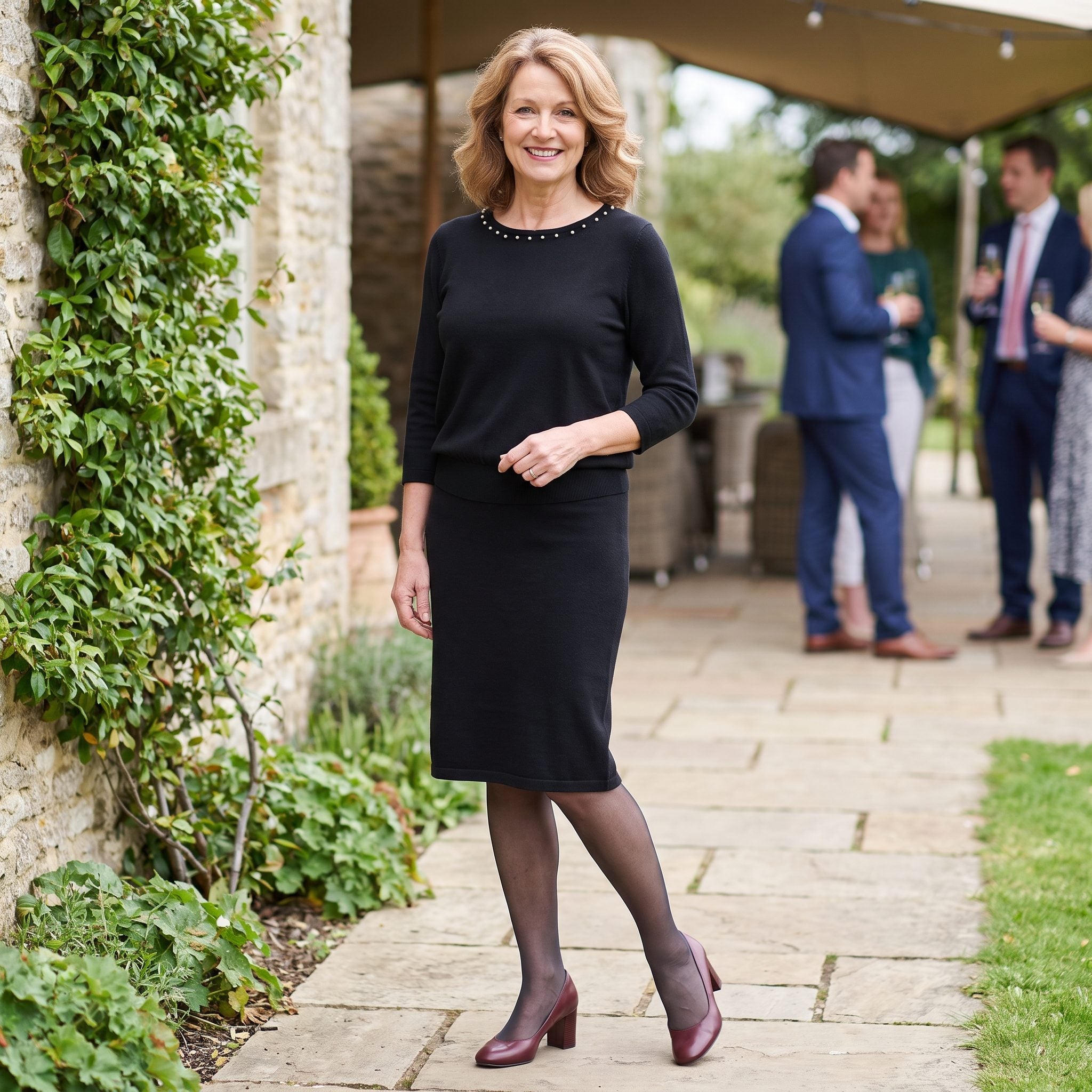 Black knit dress with pearl neckline trim and burgundy block-heel pumps
