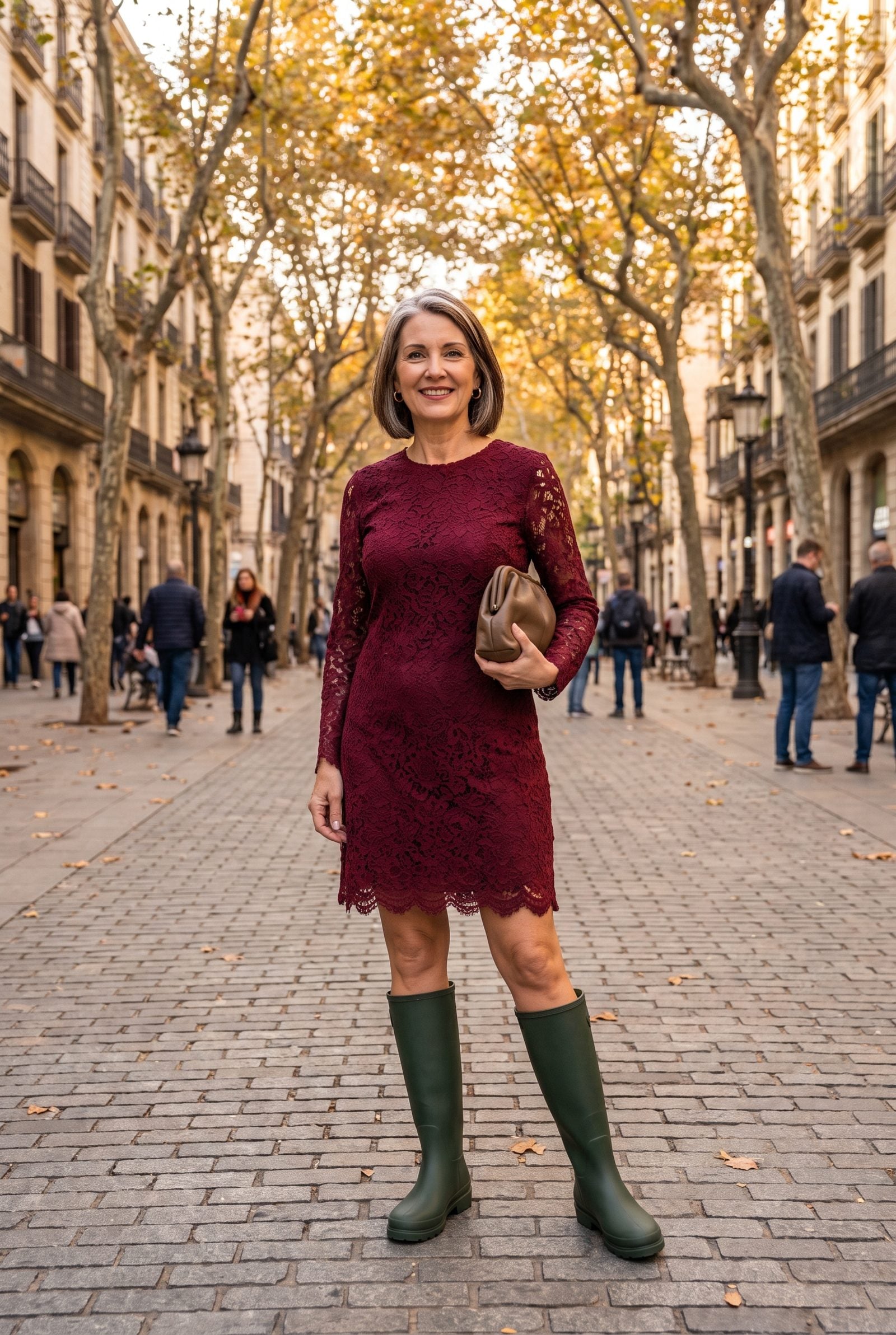Woman in a burgundy lace cocktail dress wearing flat green rubber rain boots below the knee.