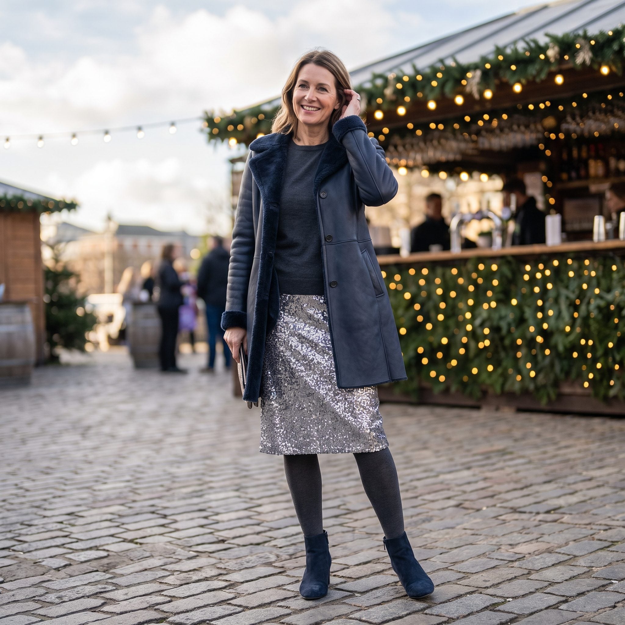 Navy leather coat layered over a silver sequin skirt