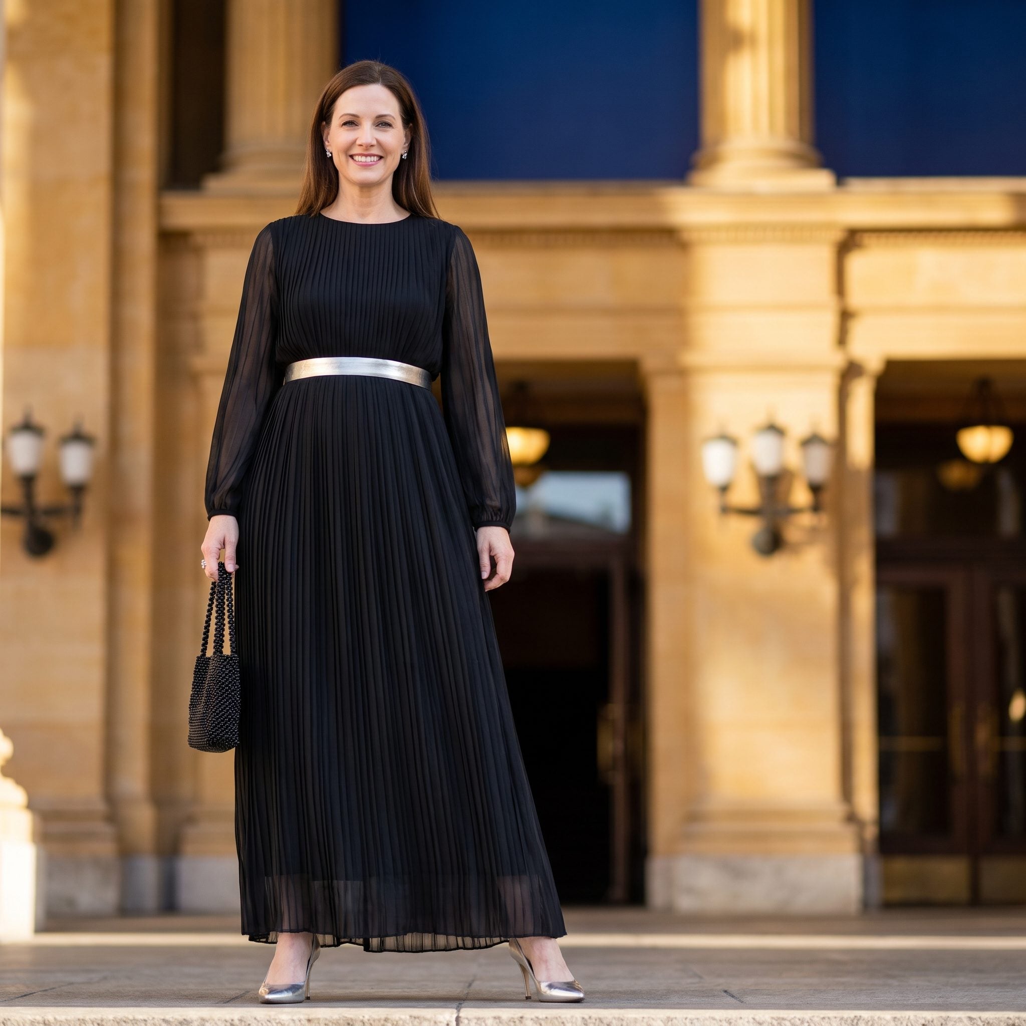 Black pleated chiffon evening dress with a silver empire belt