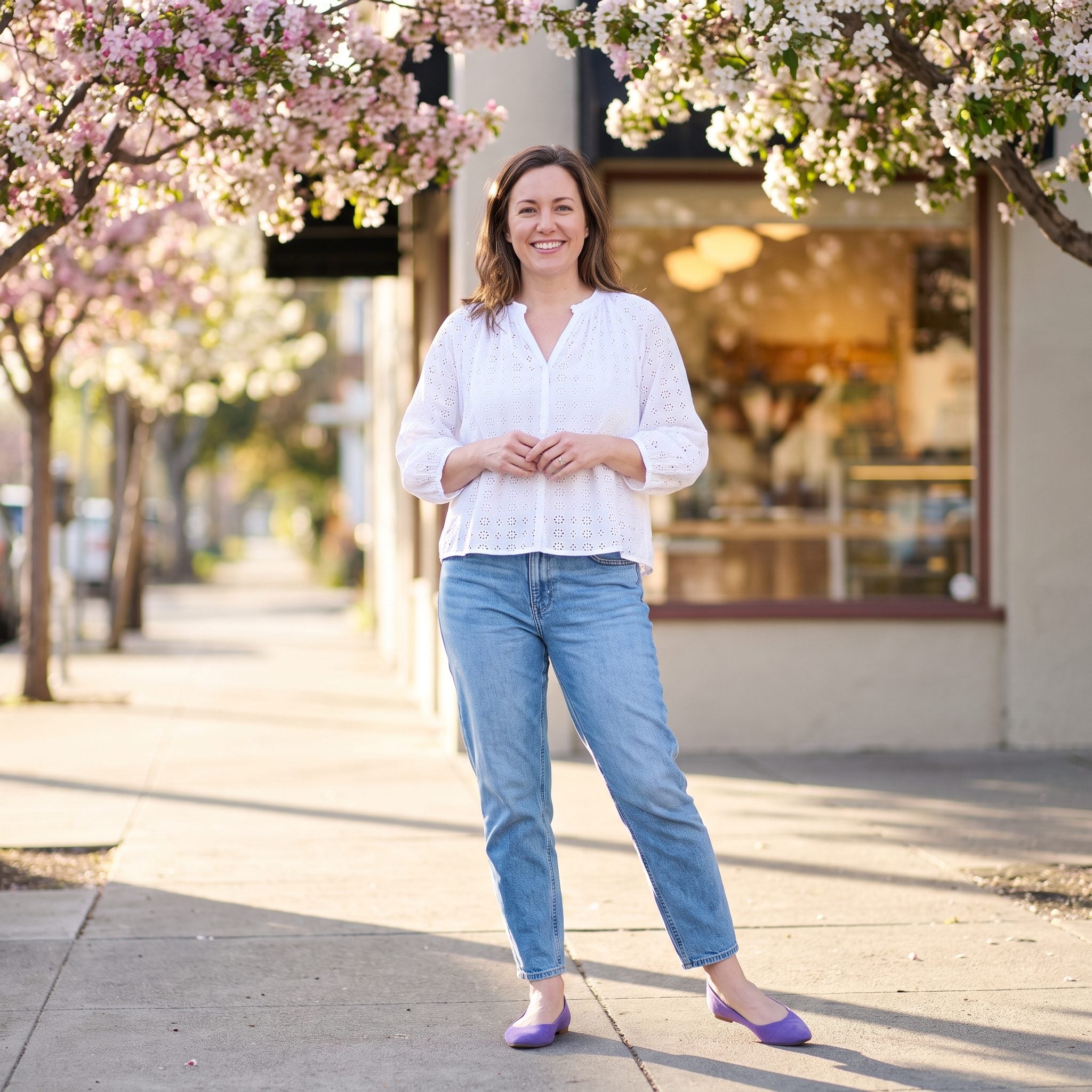 Spring outfit with relaxed tapered jeans, a white eyelet blouse, and violet flats