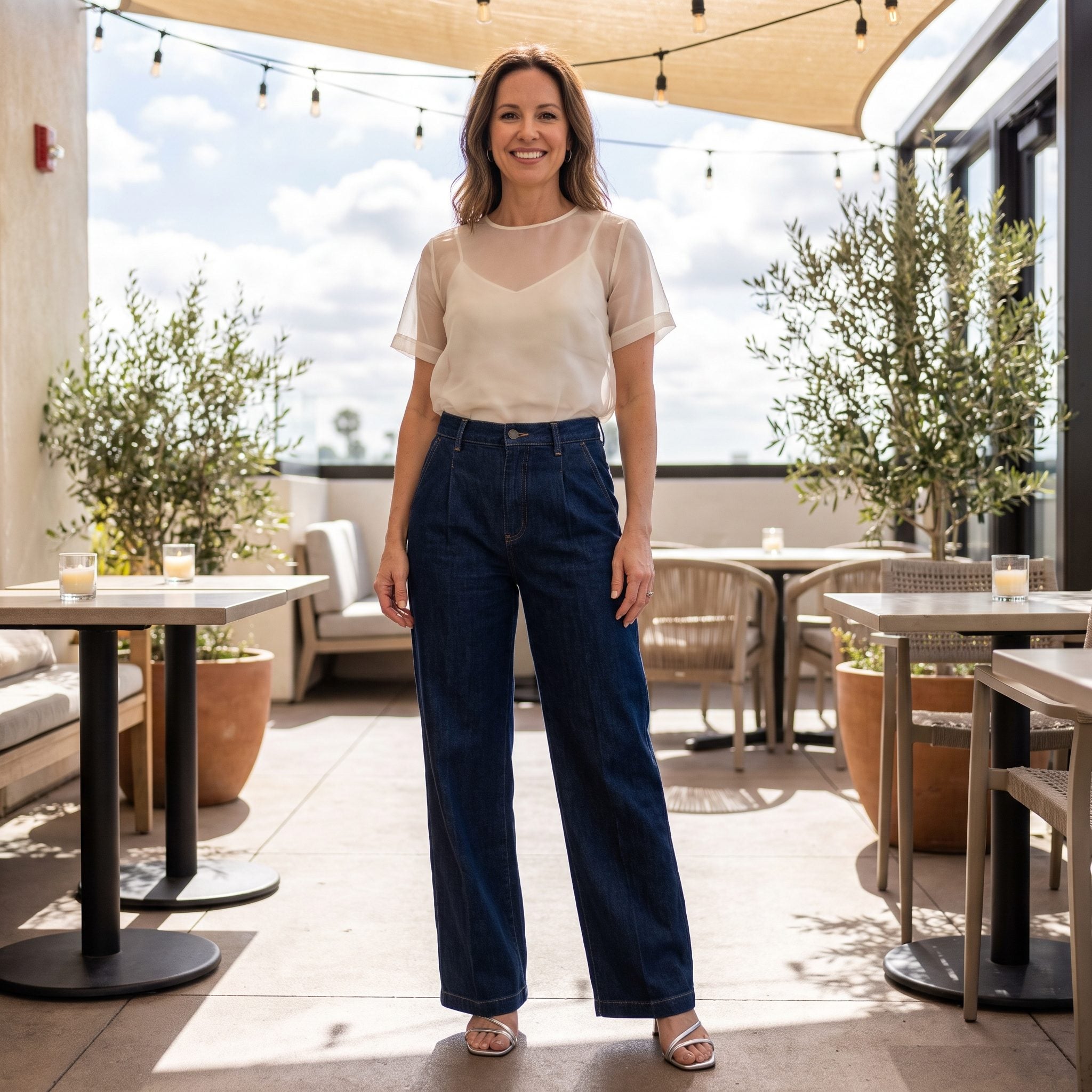Summer evening outfit with dark pleated jeans, ivory organza, and silver sandals